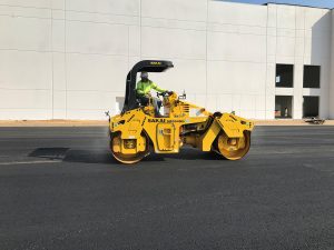 Sakai SW654ND oscillatory double drum asphalt roller 58" compaction width on a paving jobsite at a new warehouse.