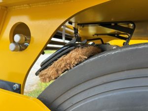 View of the optional front cocoa mats on a SAKAI GW754 vibratory pneumatic tire roller or PTR. Cocoa mats help spread water on the tires to prevent asphalt pickup.