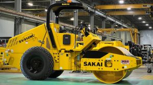 The first production ready SAKAI SV414ND oscillatory soil compactor shown in front of the Adairsville, Georgia, USA manufacturing assembly line.