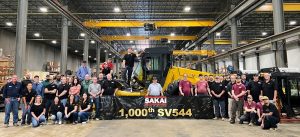 The employees of SAKAI america gather around the 1000th SV544 soil compactor in front of the assembly line at the Adairsville Georgia USA factory.