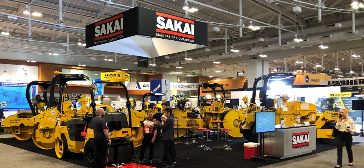 Sakai America booth as seen at the World of Asphalt trade show in 2022 with various asphalt rollers or compactors.