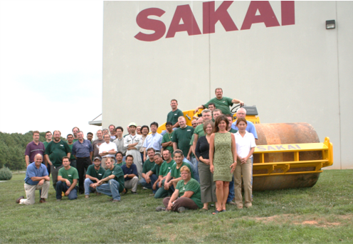 Sakai factory employees pose for a group photo with an SV505D soil compactor in front of the Adairsville, Georgia production plant to celebrate 1000 machines being built.