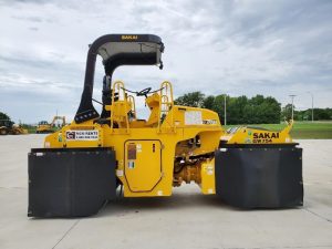 Optional heat retention skirts for the SAKAI GW754 pneumatic tire asphalt roller to prevent asphalt pickup on the mat. Side view.
