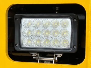 Close up of the upgraded LED light assembly on the front of a SAKAI R2H-4 threel wheel static asphalt roller.