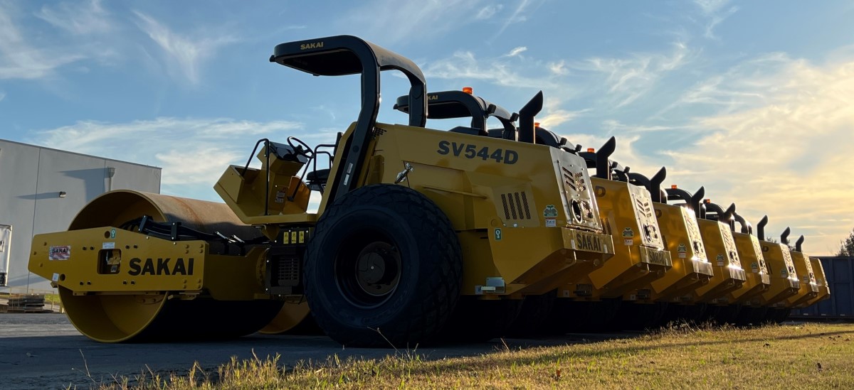 A row of many newly manufactured Sakai 84 inch 12 ton SV544 soil compactors or dirt rollers lined up in our Georgia headquarters shipping yard.