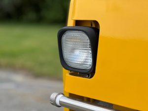 Standard halogen front light assembly on a SAKAI SW354 or SW504 series asphalt roller.