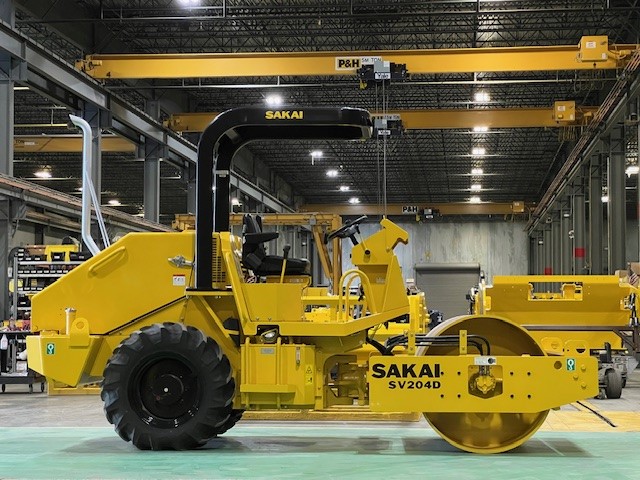 The very first SAKAI SV204 soil compactor built in the US sits in front of the assembly line after hours.