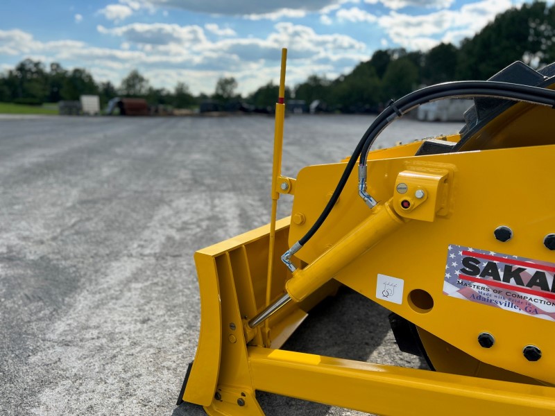 View of the back of the leveling blade or dozer blade on the Sakai SV414 soil compactor.