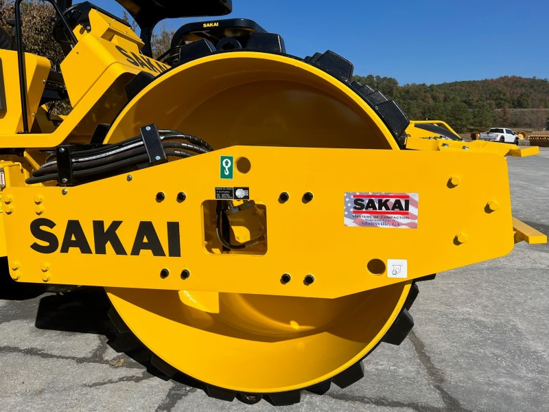 Side view of sheeps foot or pad foot shell kit over smooth drum on a SAKAI SV544D soil compactor.