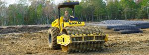A Sakai SV544T sheeps foot or padfoot soil compactor or soil roller compacting dirt on a job site in Savannah, Georgia, USA.