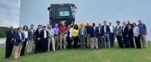 A group of Georgia lawmakers and Japanese officials pose for a photo in front of an SW994 asphalt roller outside of the Adairsville Georgia SAKAI America manufacturing facility.