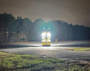 Night time view of the fully illuminated optional LED lighting on a SAKAI asphalt roller.