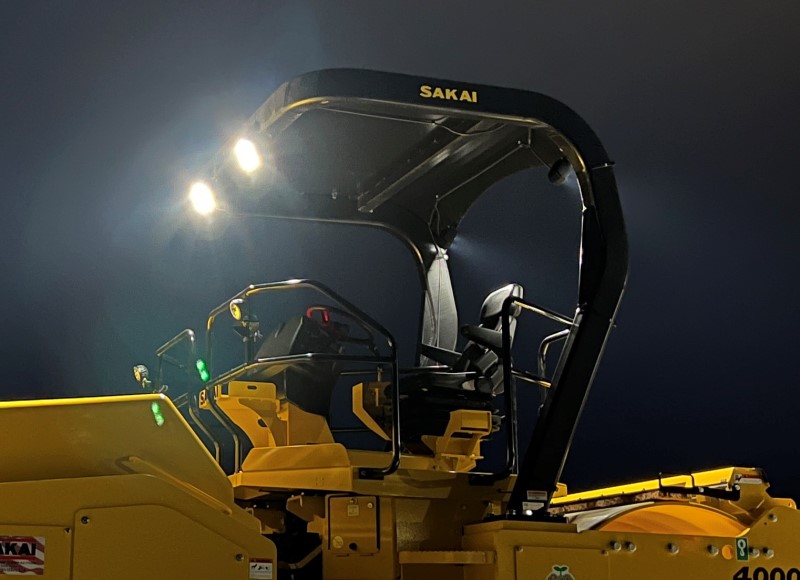 Optional LED work lights illuminated at night on our SW884 asphalt roller provide additional lighting for night paving.