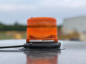 Magnetic beacon or strobe mounted to the top of the ROPS on a SAKAI asphalt compactor.