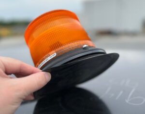 Rubberized magnetic base on the LED amber strobe light or beacon, which is an accessory available on large asphalt rollers.