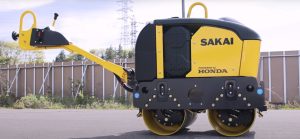 SAKAI electric battery powered walk behind asphalt roller prototype outdoors.