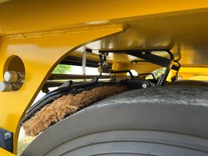 Side of the optional front coco mats on a SAKAI GW754 vibratory pneumatic tire roller or PTR. Coco mats help spread water on the tires to prevent asphalt pickup.