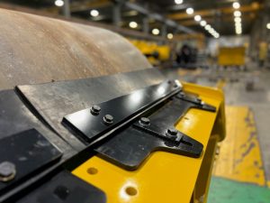Adjustable vulcanized rubber scraper blade option for 8 ton smooth drum Sakai SV414 soil compactors.